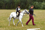 White pony and rider being lead