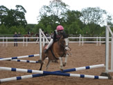 Pony and rider jumping in competition