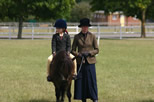 Pony, rider and trainer standing