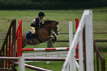 Pony and rider jumping red bar fence jumps